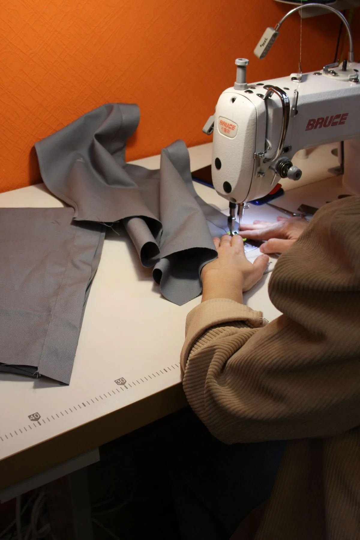 Fabric being guided through a sewing machine, illustrating garment construction